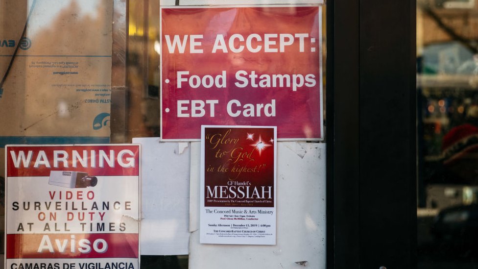 Un negocio con un cartel en el que se informa que aceptan "food stamps" como forma de pago.