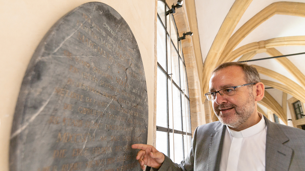 Crkveni zvaničnik Norbert Jung ispred nadgrobne ploče