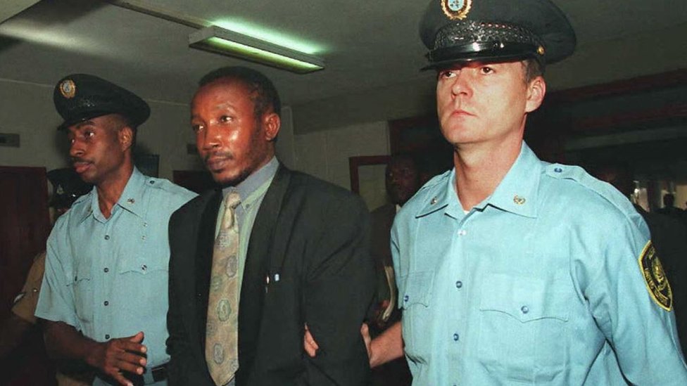 Jean-Paul Akayesu is escorted to the International Criminal Tribunal for Rwanda by United Nations security agents