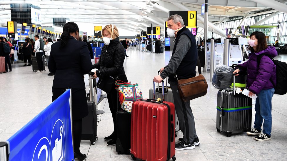 Путешественники выстраиваются в очередь на рейс в аэропорту Хитроу в Лондоне, Великобритания, 14 марта 2020 г.