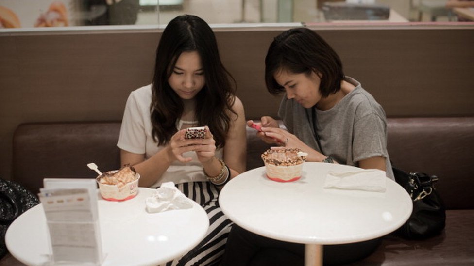 Две девушки болтают по телефонам