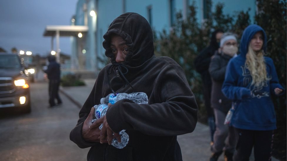 Una mujer lleva agua embotellada que recibió de un refugio después de temperaturas récord en Galveston, Texas, el 18 de febrero de 2021