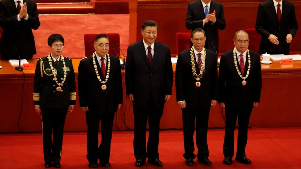 Xi Jinping y los cuatro sanitarios condecorados.
