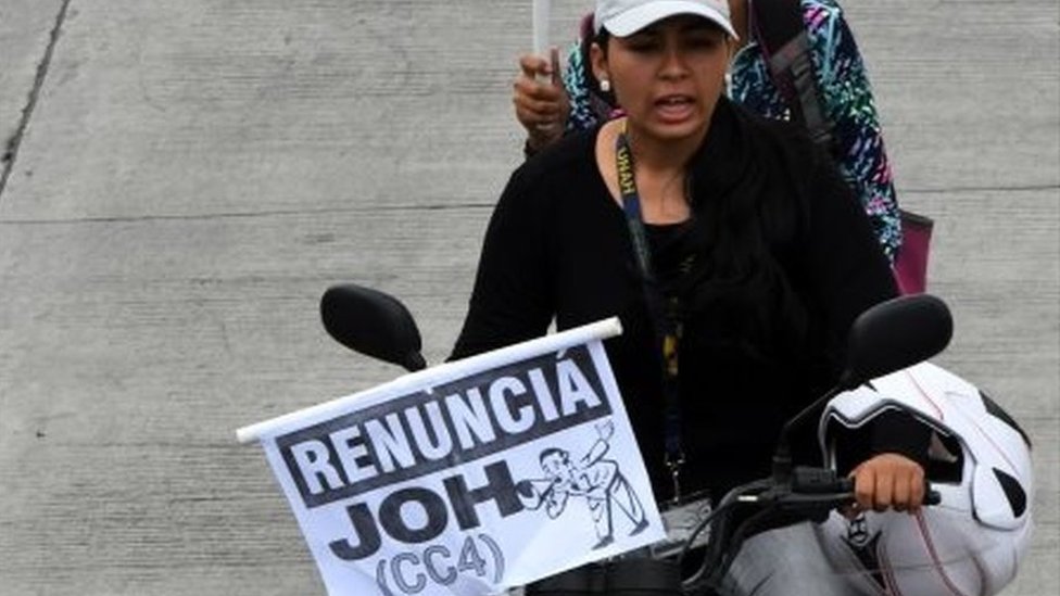 Протестующие на мотоцикле держат плакаты с надписью «подать в отставку, JOH (CC4)