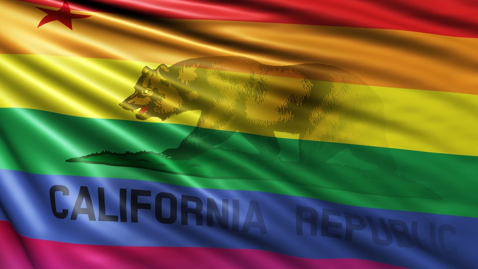 La bandera del estado de California intervenida con la bandera que identifica a la comunidad LGBTI