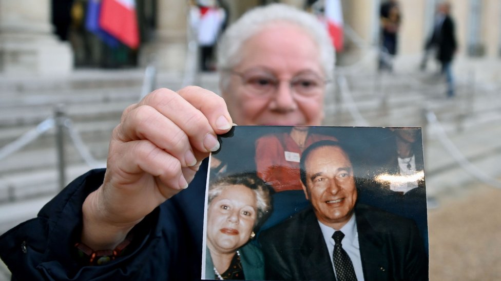 Эта женщина по имени Эдит держала фотографию себя с бывшим президентом, когда она выражала свое почтение в Елисейском дворце
