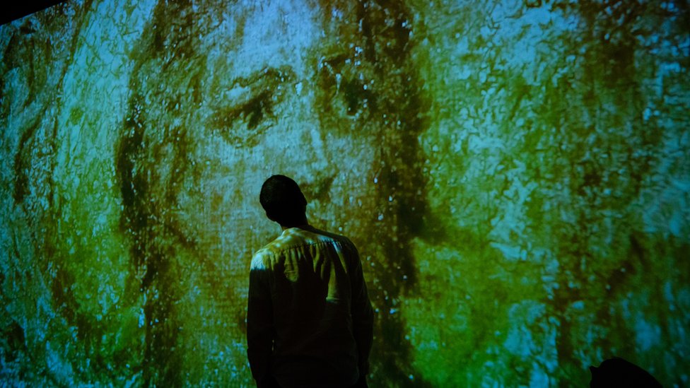 Посетитель галереи Тейт Британ стоит перед проекцией Уильяма Блейка