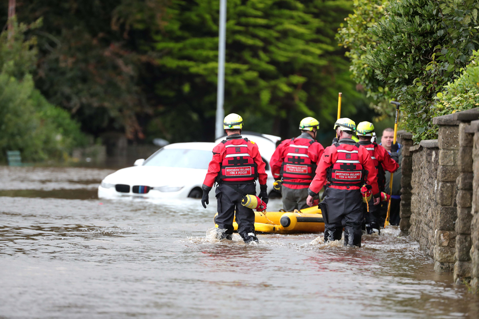Emergency services attend a flooded street