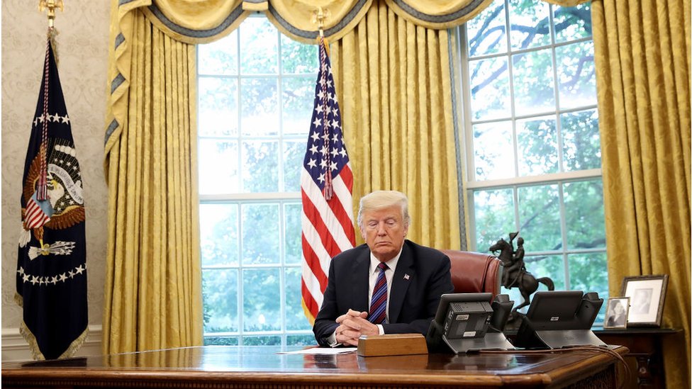 President Donald Trump speaks on the telephone via speakerphone with Mexican President Enrique Pena Nieto in the Oval Office of the White House on August 27, 2018