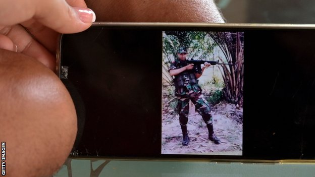 Florian and his wife Angie show a photo of Florian as a soldier