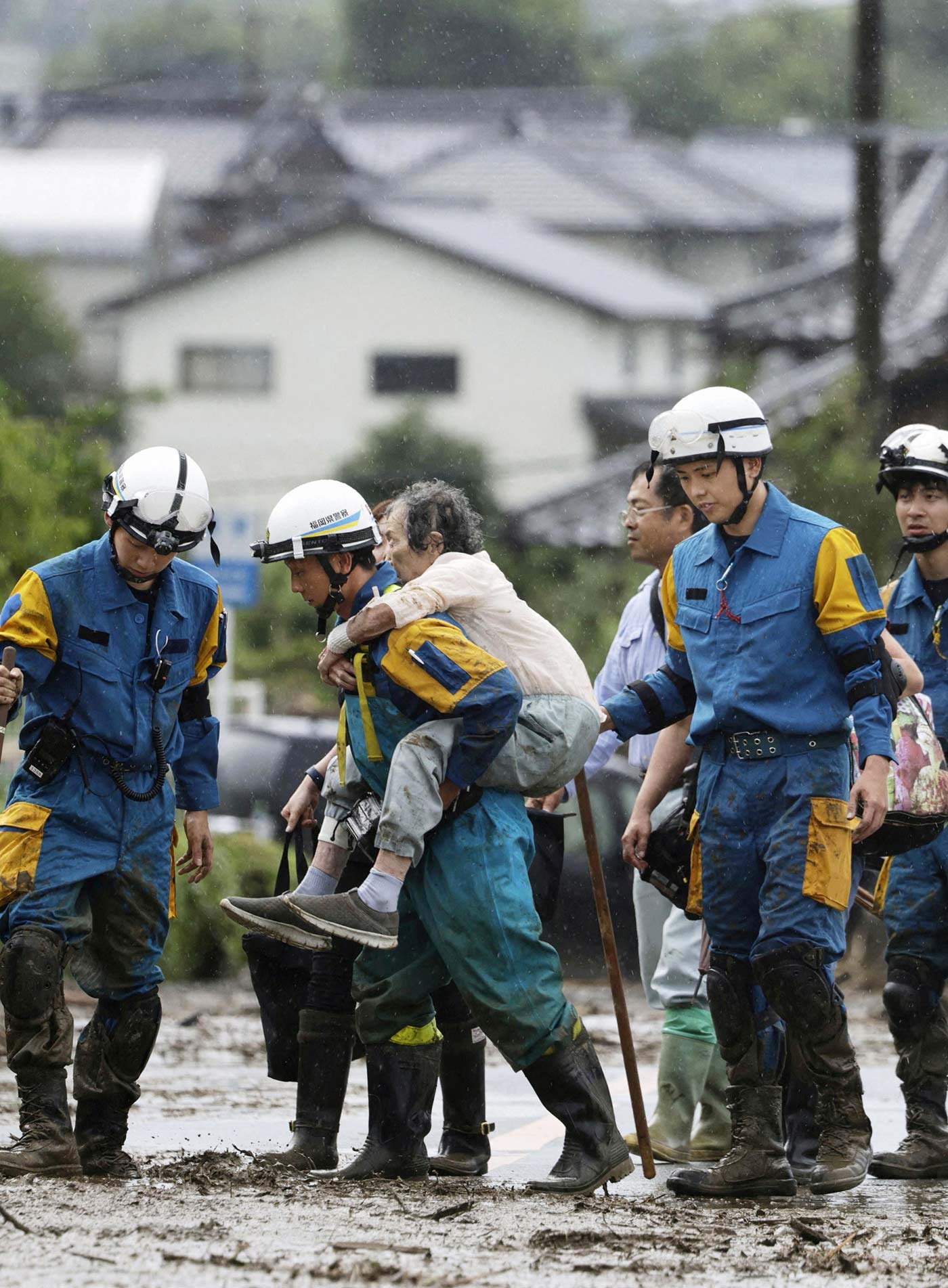 Police officer carries a local resident from the site of a landslide caused by heavy rains in Kurume, Fukuoka Prefecture - 10 July 2023