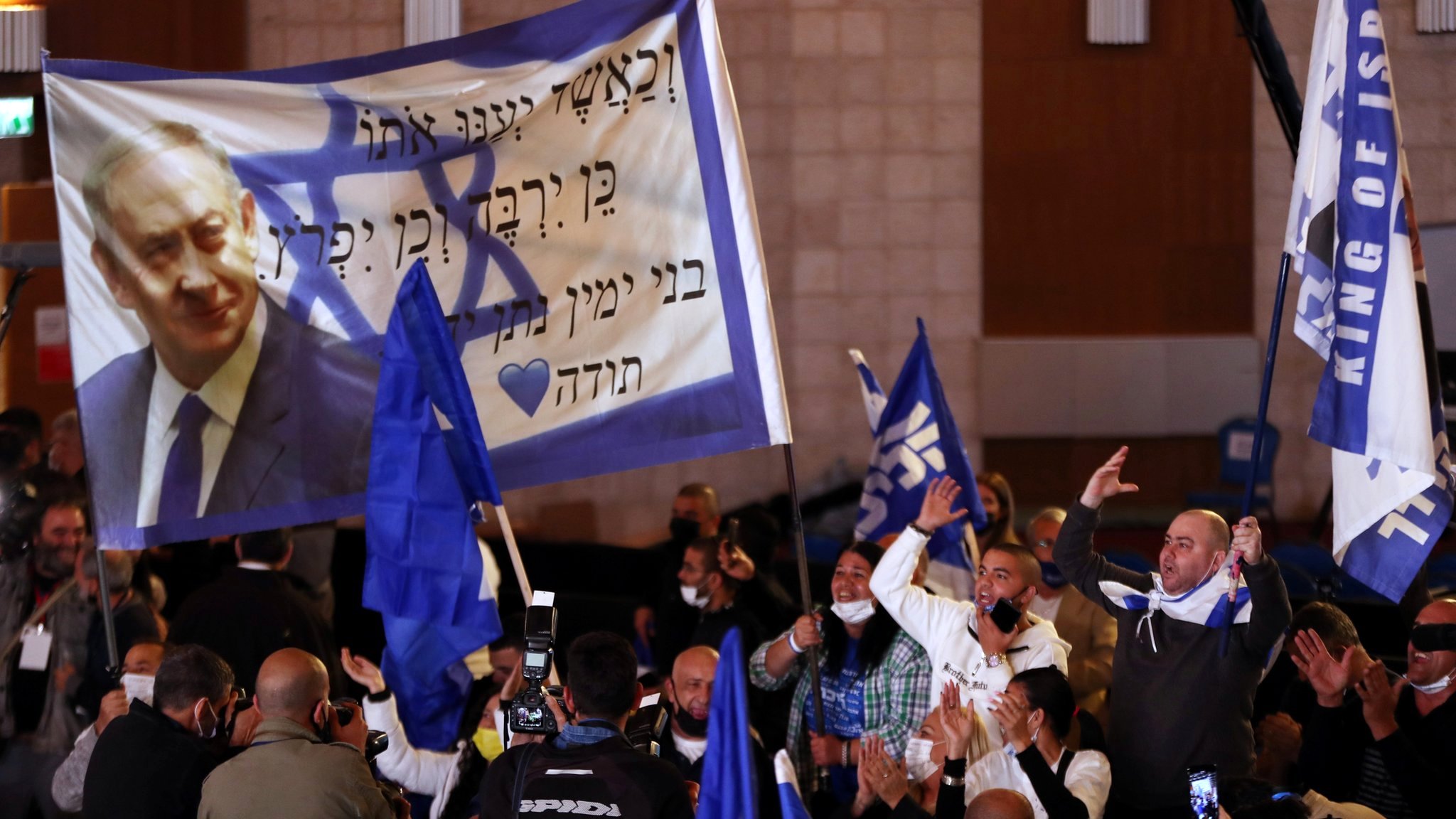 Supporters of Israeli Prime Minister Benjamin Netanyahu's Likud party react following the release of exit polls for the general election on 23 March 2021