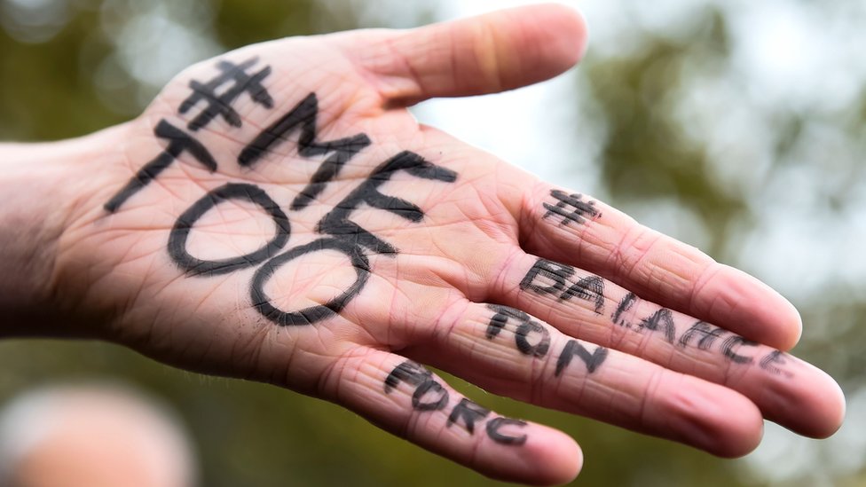 #MeToo y #BalanceTonPorc escritos en la palma de una mano.