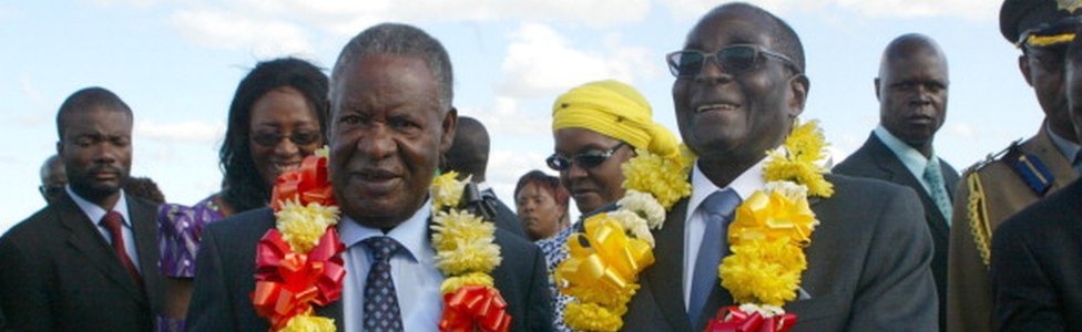 Роберт Мугабе (справа) приветствует президента Замбии Майкла Сата (слева) по прибытии в Хараре 25 апреля 2012 года с двухдневным государственным визитом