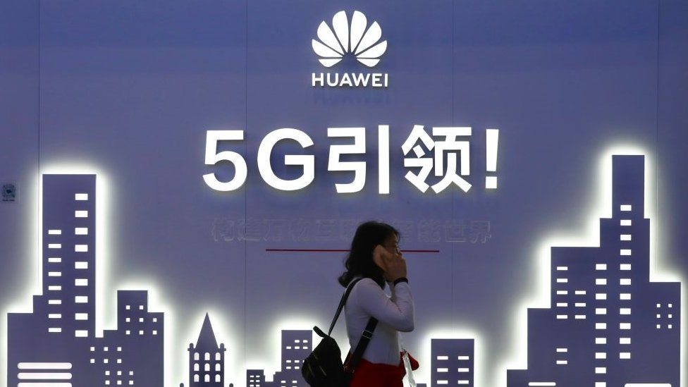 A woman walks past Huawei 5G sign on the opening day of PT Expo China 2019 at the China National Convention Center on October 31, 2019 in Beijing, China.