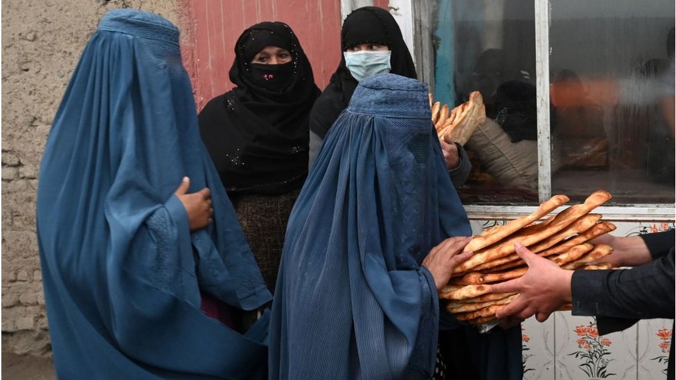 Perempuan yang mengenakan Burqa menerima roti gratis yang didistribusikan sebagai bagian dari kampanye Save Afghans From Hunger.