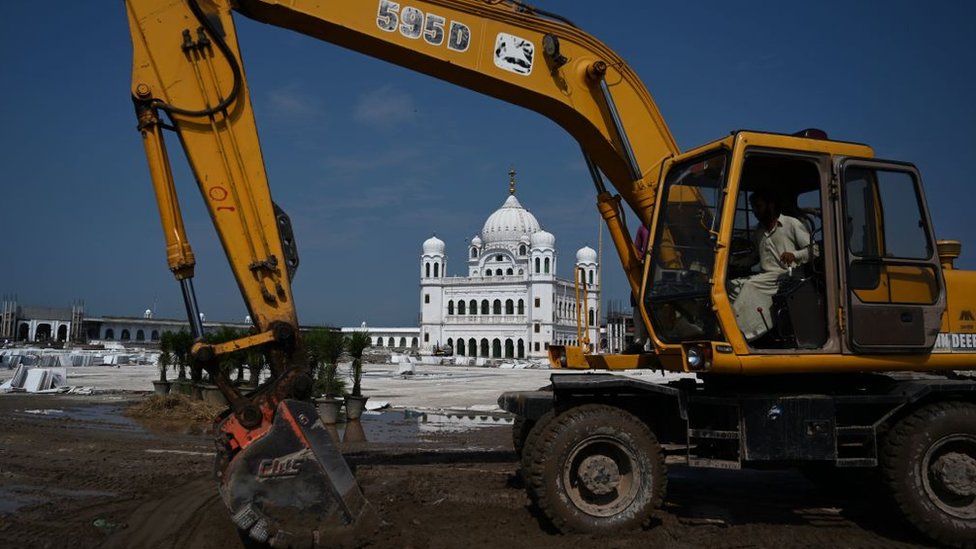 На этом снимке, сделанном 16 сентября 2019 года, рабочий использует экскаватор для выравнивания земли на сикхском религиозном месте Гурдвара Дарбар Сахиб в пакистанском городе Картарпур недалеко от границы с Индией.
