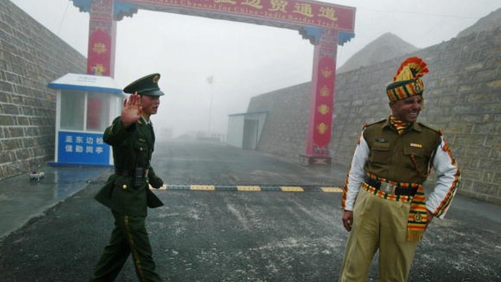 Китайский солдат и индийский солдат охраняют китайскую сторону древнего пограничного перехода Натху Ла между Индией и Китаем в 2008 году