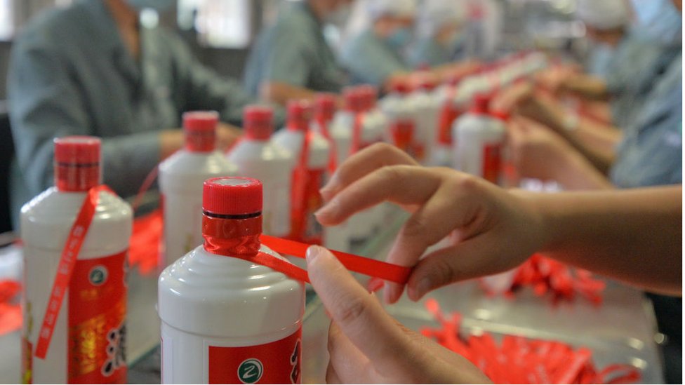 Сотрудники упаковывают Квейчоу Мутаи на заводе в Китае.