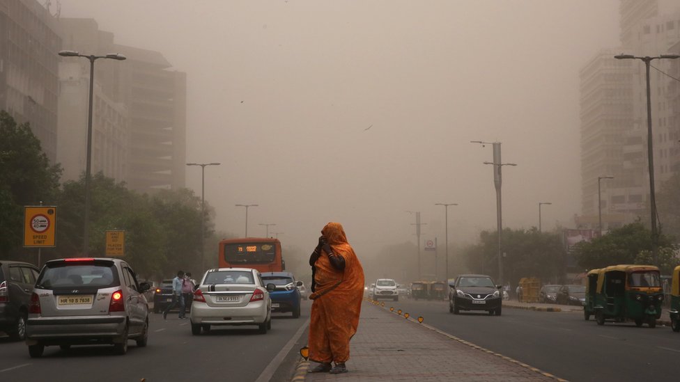 Una mujer camina con su rostro cubierto en medio de una tormenta de polvo y arena en Nueva Delhi, India.
