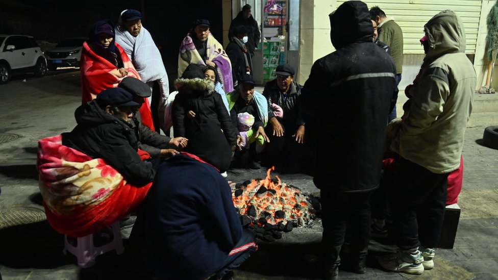 Residents gather around a fire to keep warm on a street after a 6.2-magnitude earthquake on December 19, 2023 in Jishishan Bonan, Dongxiang and Salar Autonomous County, Linxia Hui Autonomous Prefecture, Gansu Province of China.