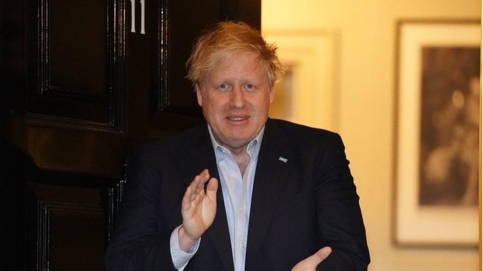 O primeiro ministro britânico Boris Johnson olha para a câmera e dá um meio sorriso com as sobrancelhas franzidas