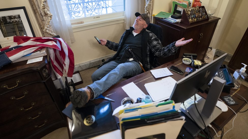 A supporter of US President Donald Trump sits at a desk in Congress building