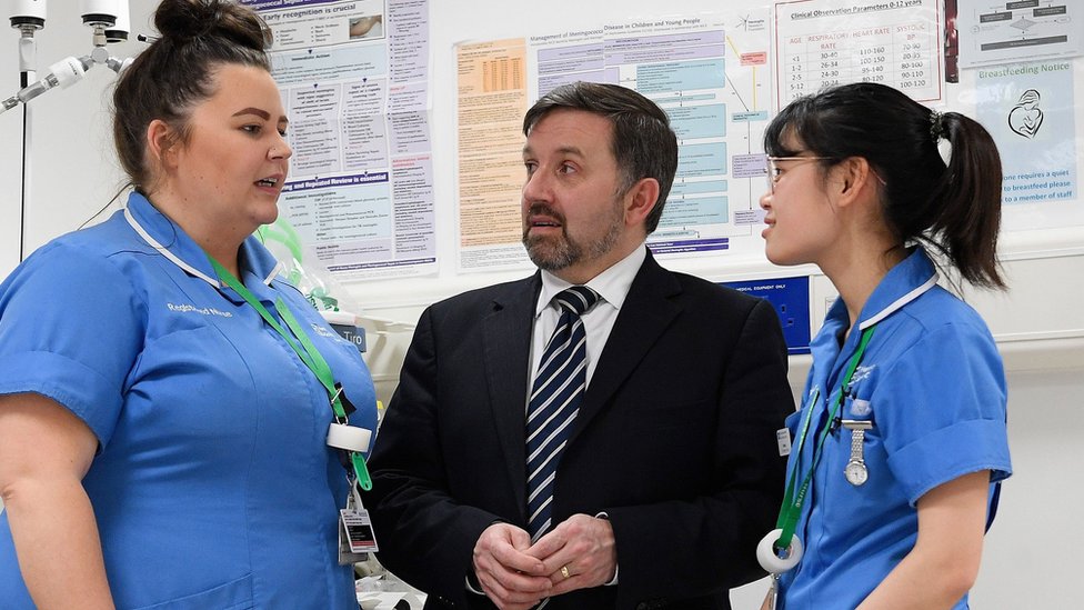 Министр здравоохранения Робин Суонн (в центре) с медсестрами Эмбер Лунг (справа) и Джиллиан Браун во время посещения отделения неотложной помощи больницы Ольстера в Дандональде в январе