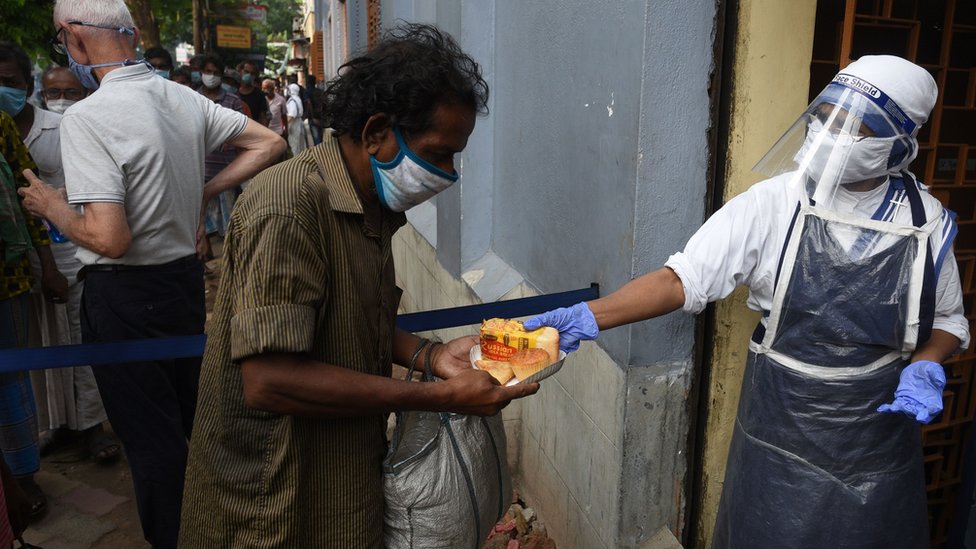 Members of The Missionaries of Charity distribute food to underprivileged people