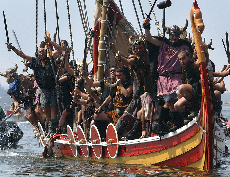 La gente del pueblo de Catoira, en Galicia, noroeste de España, el 05 de agosto de 2007 simula el asalto de guerreros escandinavos, con atuendo vikingo con una réplica de un barco vikingo en la costa de Galicia hace 1000 años.