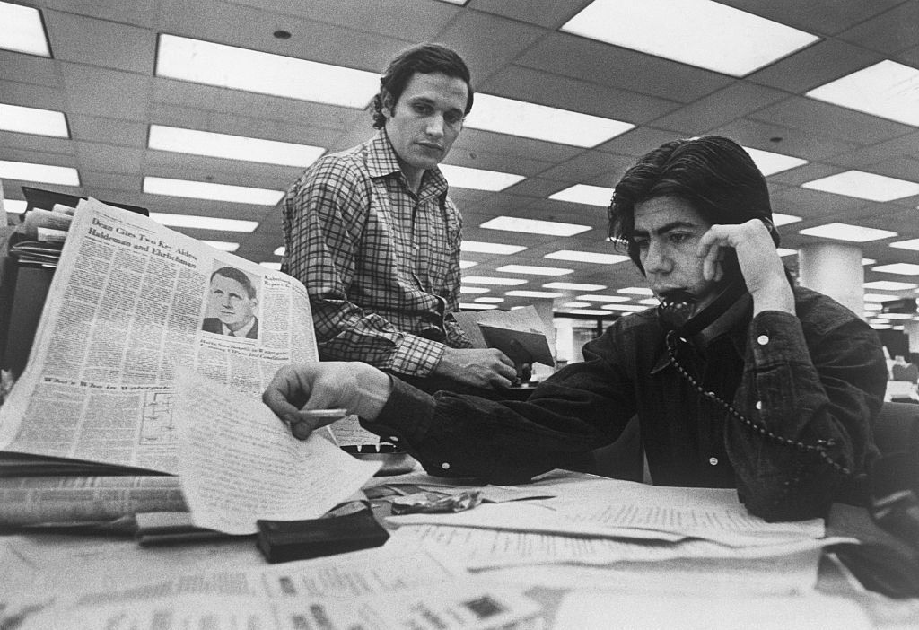Bob Woodward y Carl Bernstein (al teléfono) investigando el caso de Watergate en la sede del Washington Post