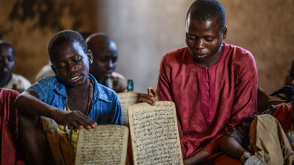 Дети из разных районов Нигерии учатся читать и запоминать стихи Корана, написанные чернилами на деревянных панелях в школе-интернате в Джимете, Нигерия, 8 декабря 2014 г.