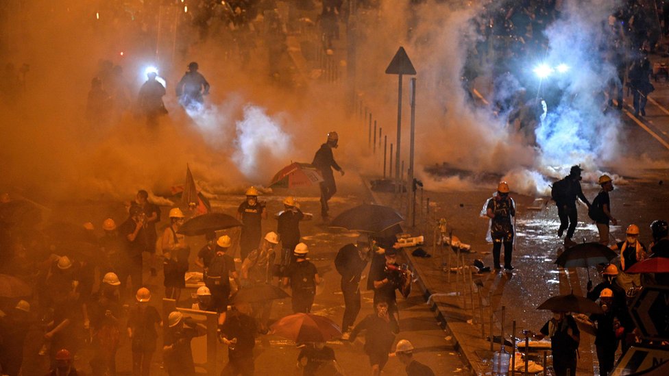 Полиция стреляет слезоточивым газом по демонстрантам возле здания правительства в Гонконге