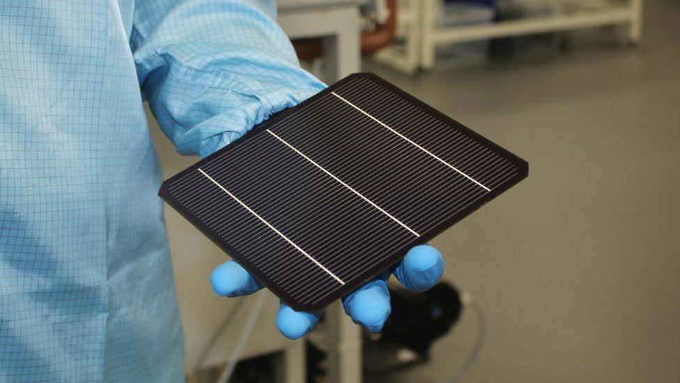 Solar panel about the size of a tablet being held in a lab