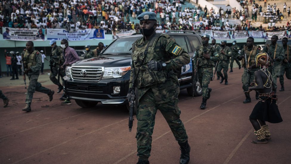 Кортеж президента Центральноафриканской Республики прибывает к стадиону на 20 000 мест для предвыборного митинга в сопровождении президентской гвардии, российских наемников и руандийских миротворцев ООН