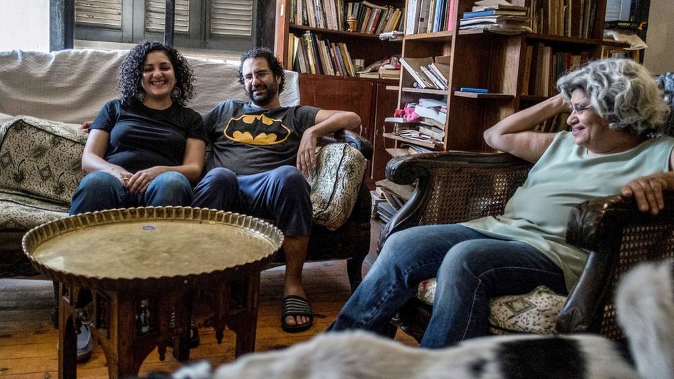 Egyptian activist and blogger Alaa Abdel Fattah (C) smiles next to his mother Laila Soueif (R) and sister Mona Seif (L) in Giza (17 May 2019)