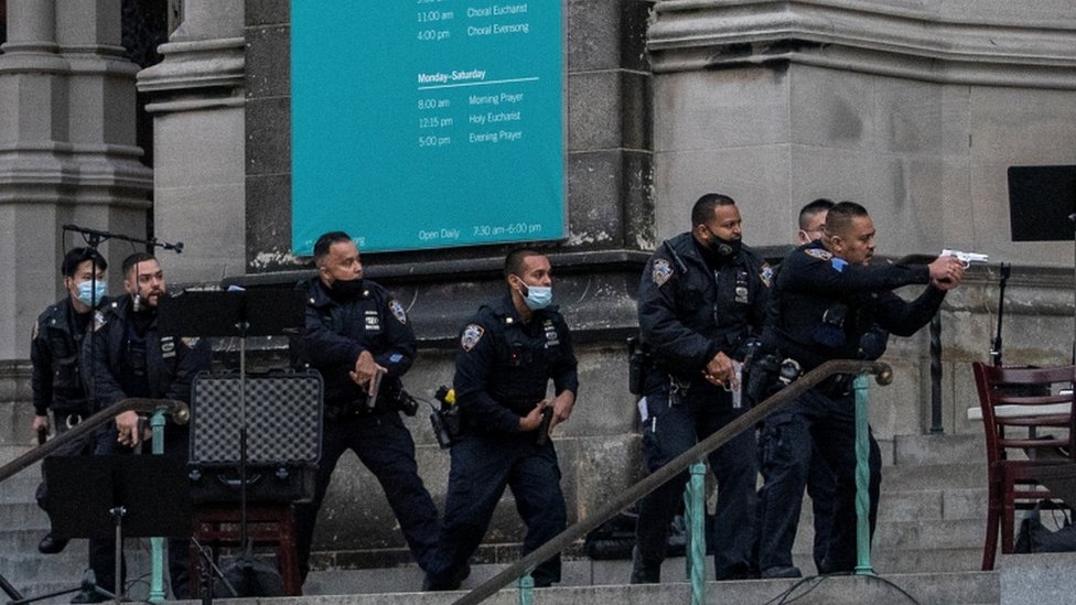 Офицеры приближаются к бандиту возле собора в Нью-Йорке