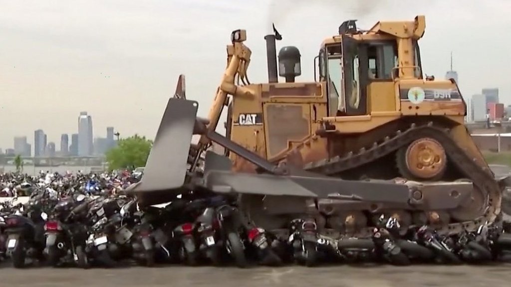 Bulldozer crushes 100 seized vehicles in New York