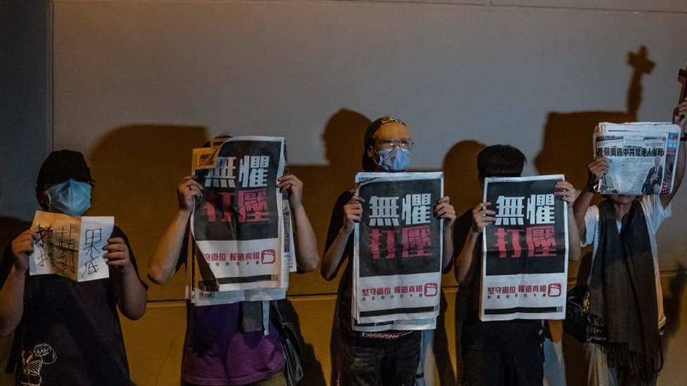 Activistas prodemocracia mostrando ejemplares del diario de Lai "Apple Daily".