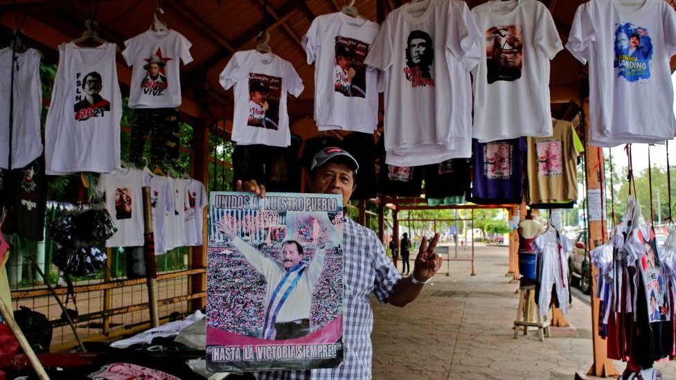 Un hombre sostiene un cartel de propaganda de Daniel Ortega