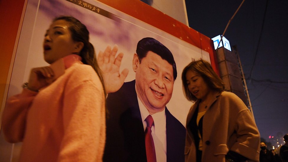 北京市民走在習近平的海報旁。