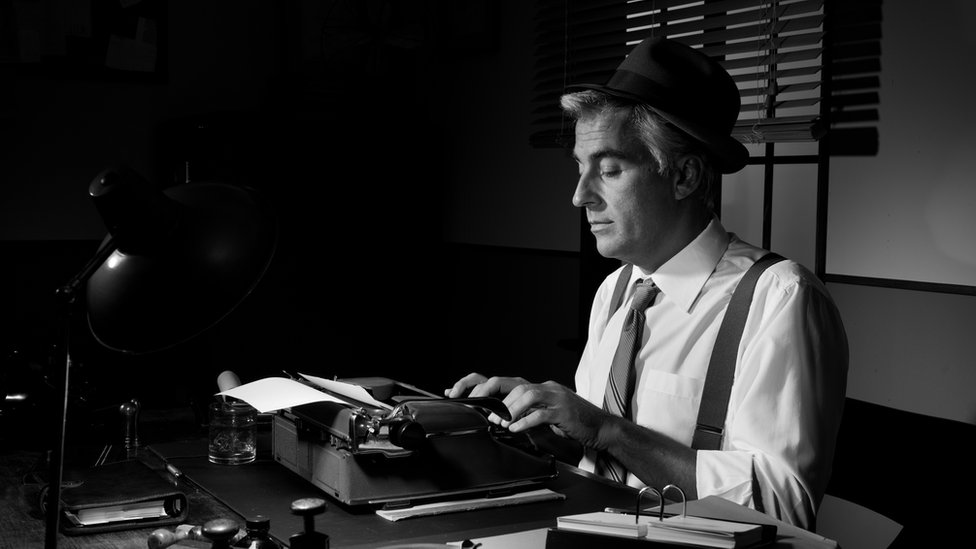 Черно-белое изображение человека, отчаянно печатающего на пишущей машинке