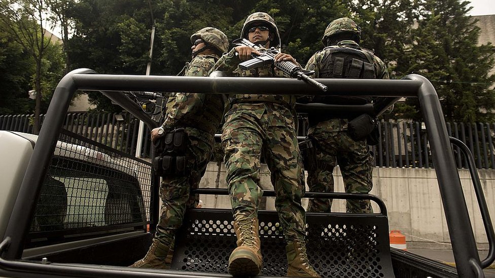 Miembros de las fuerzas federales fuertemente armados en un auto