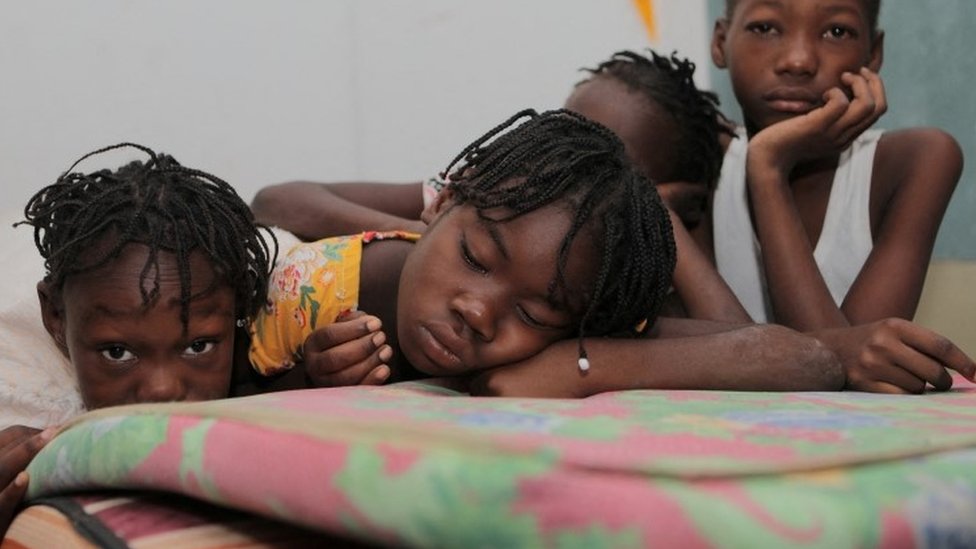 Varios niños refugiados en una escuela en la capital de Haití miran a la cámara.