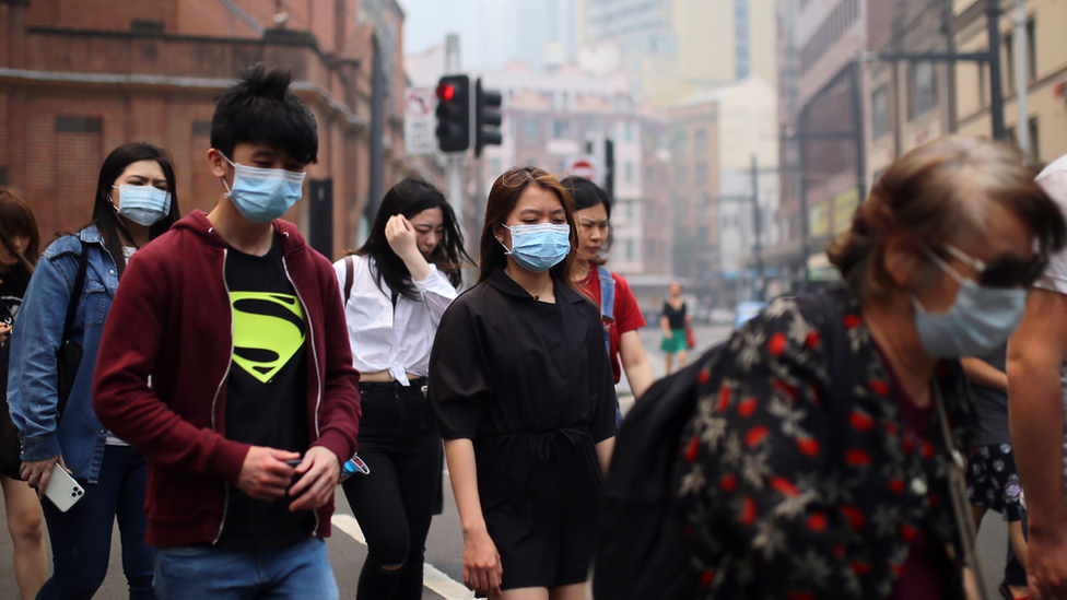 Прогуливаясь по Сиднею, люди носят маски
