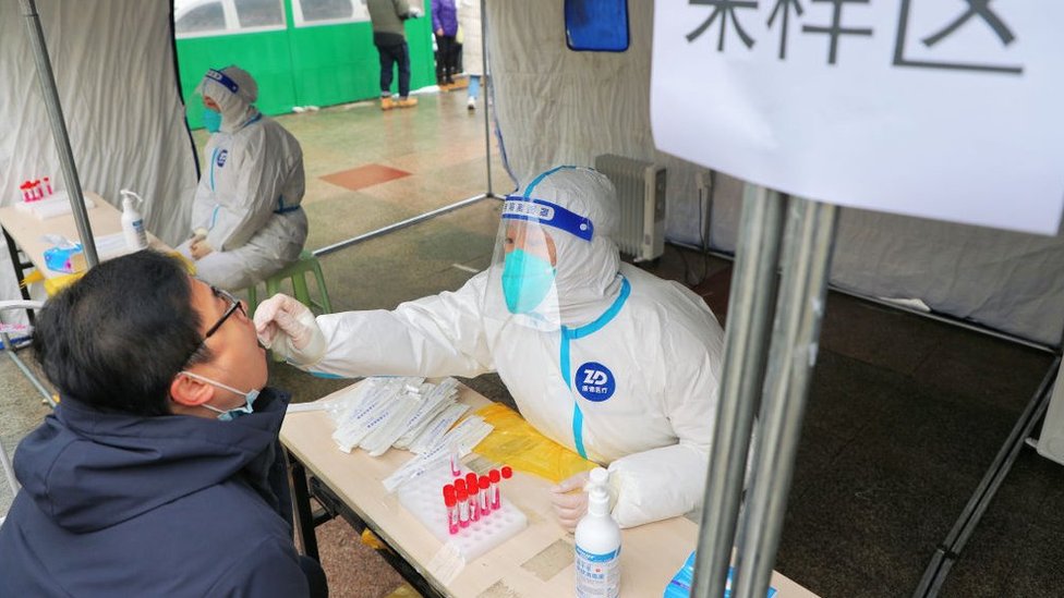 Un hombre es sometido a una PCR de garganta profunda en Pekín.