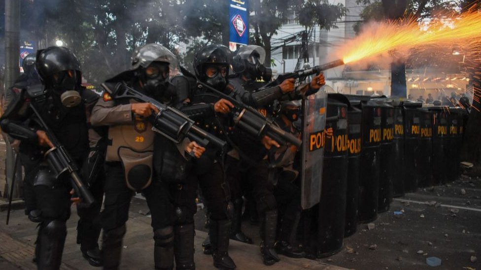 Indonesian riot police disperse protestors with tear gas in Bandung on Wednesday.