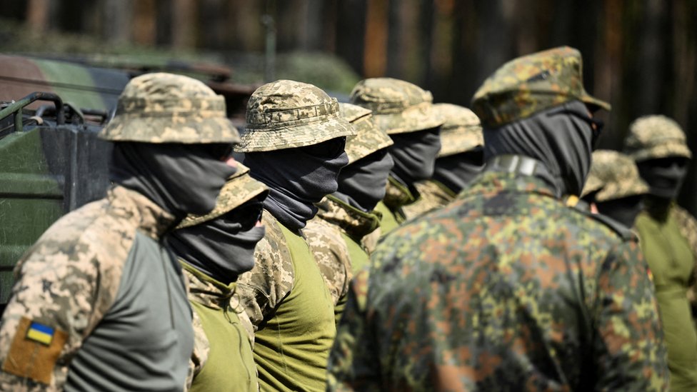 Ukrainian soldiers stand at attention