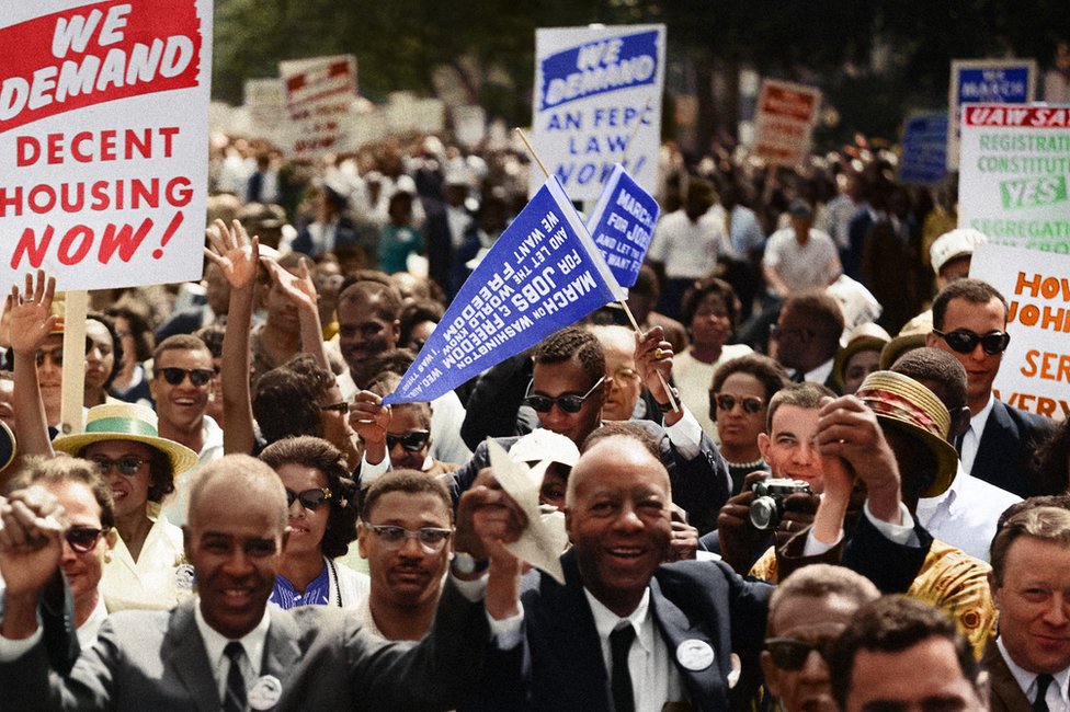 Участники марша приветствуют и машут плакатами на Марше за гражданские права в Вашингтоне