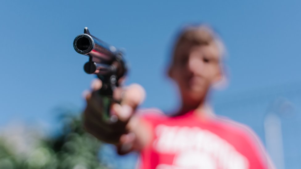 Adolescente apunta un revolver